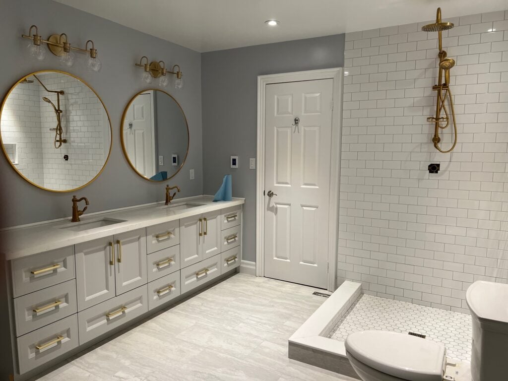 newly renovated bathroom with white Jack & Jill vanity and corner walk-in shower