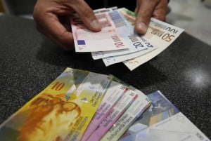 A illustration picture shows a Swiss Post clerk as he exchanges Swiss francs into Euros at a counter in a Swiss Post office in Bern