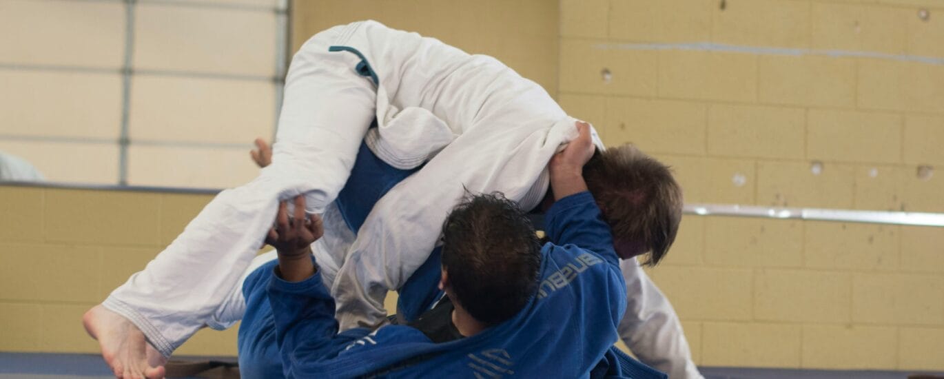 Lutadores de Jiu-Jitsu treinando no tatame – representação da história do Jiu-Jitsu.
