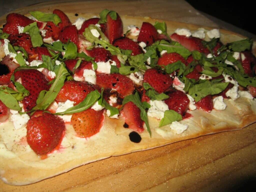 Image shows strawberry goat cheese pizza.