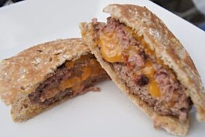 Bacon cheddar stuffed burger sliced on a plate