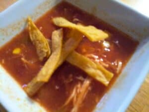 Image shows homemade tortilla soup in a bowl.