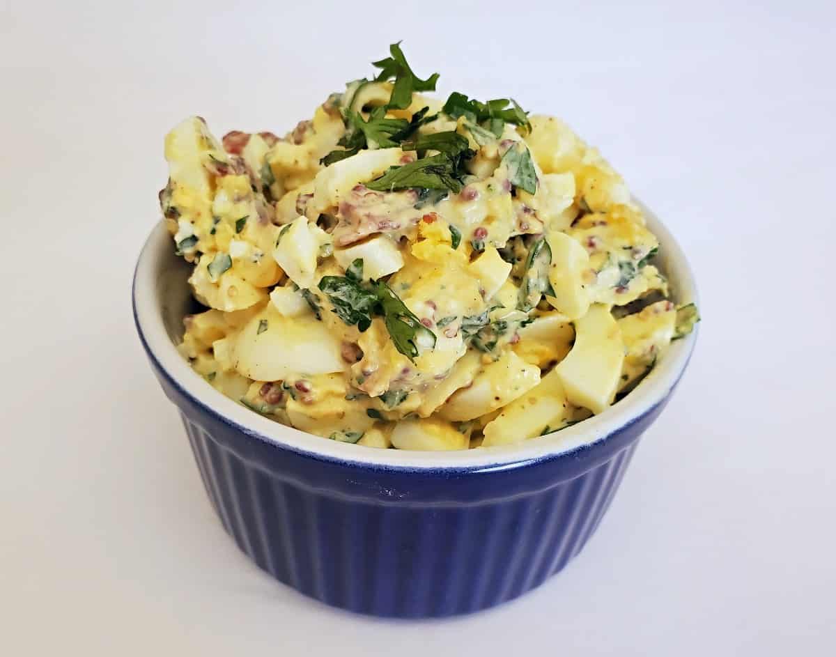 Gourmet egg salad in a blue ramekin.