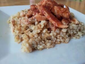 Image shows sweet tomato chicken on top of rice.