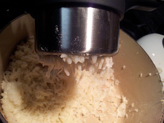 Rice potatoes in batches or use the back of a fork