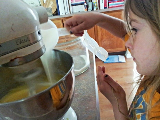 Little Miss adding the sugar while beating