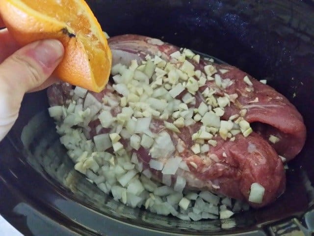 Squeezing orange juice into crock pot for carnitas