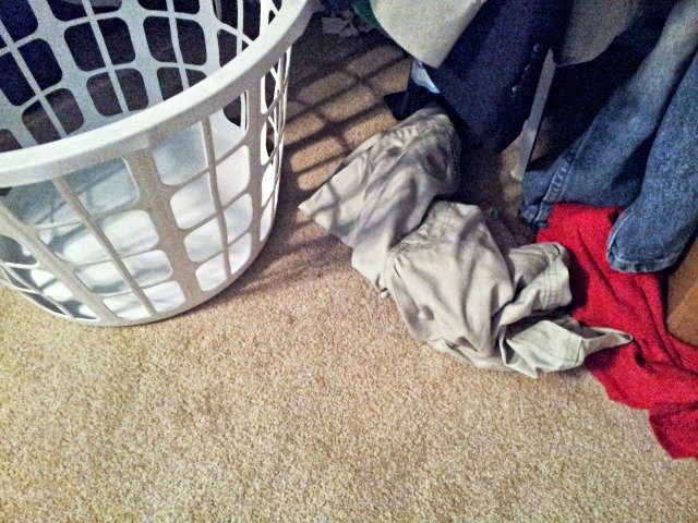 Laundry sitting all around but not in the basket