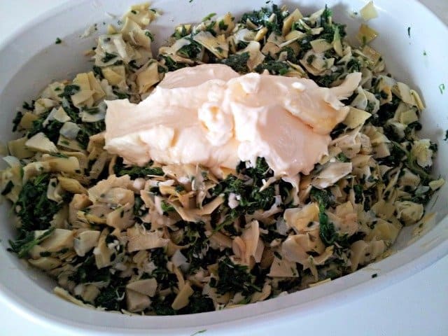 Keep mixing ingredients for your spinach artichoke dip to ensure they are well combined