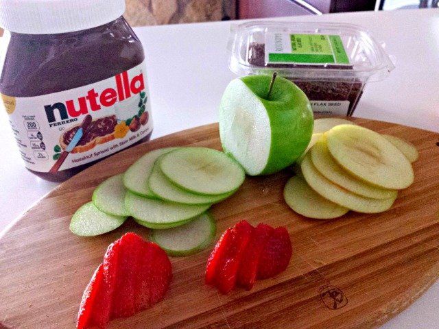 Prep your ingredients for the sandwich, cutting your apples thinly and the strawberries a bit thicker