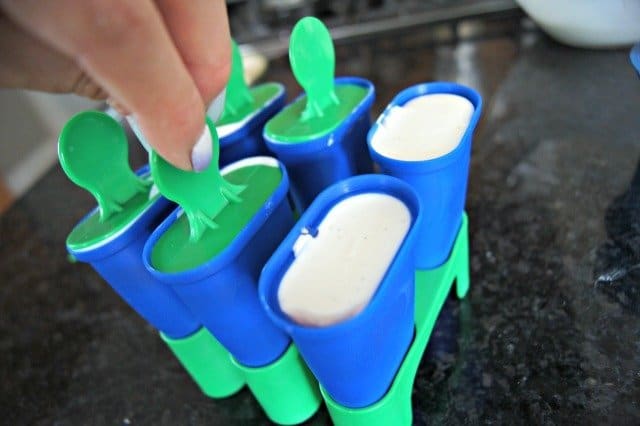 Adding sticks to soon to be frozen Greek yogurt pops
