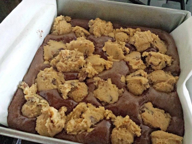 Cookie dough balls dropped onto half baked brownies