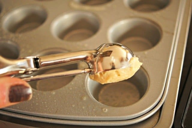 Adding batter to cupcake tins
