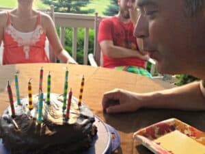 Blowing out candles of homemade strawberry cake