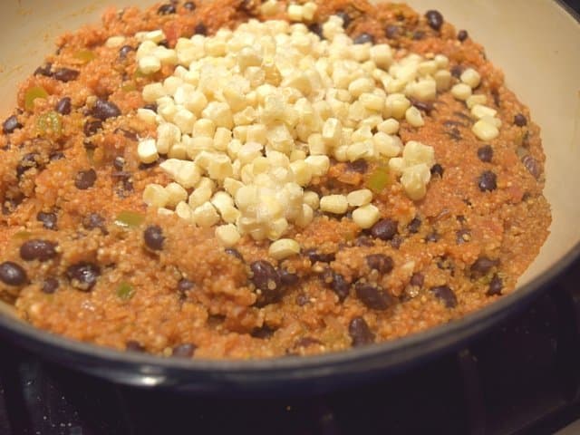 Add frozen corn to cooked quinoa and stir