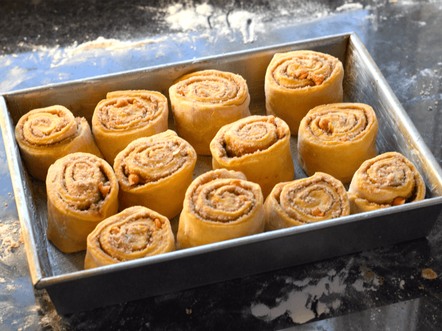 Stack pumpkin cinnamon rolls in your buttered pan