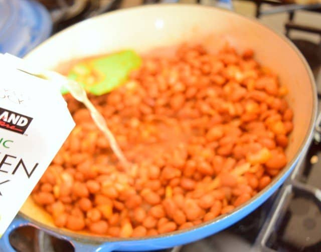 Add chicken stock to cooked onions and beans