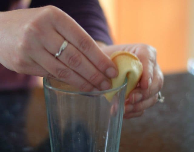 Carefully fold the fortune cookie over the rim of a glass