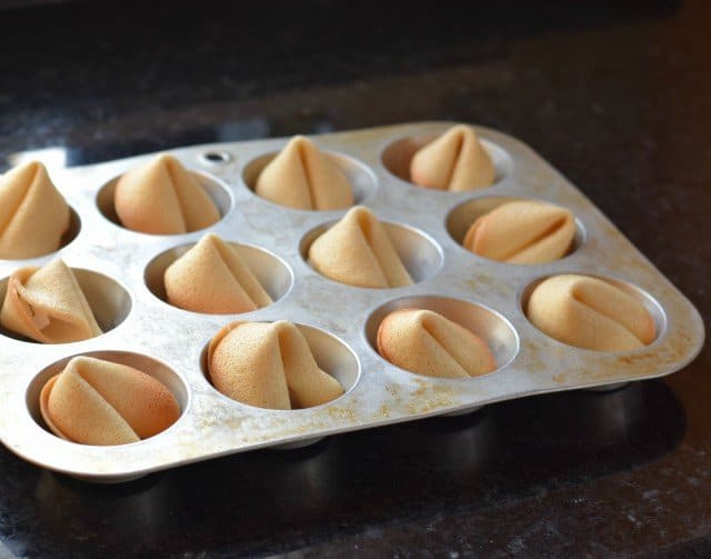 Place fortune cookies in a muffin tin to cool
