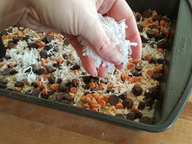 Sprinkle coconut as the top layer of the gluten free seven layer bars