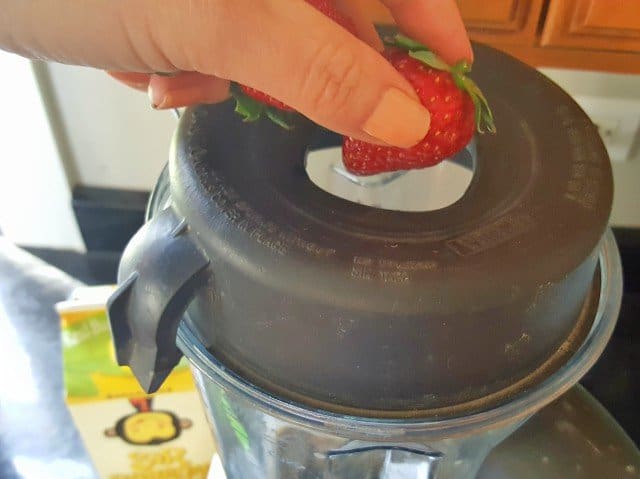 Add frozen strawberries to protein power smoothie bowl