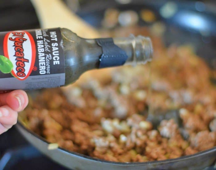 Add El Yucateco black label sauce to honey habanero beef empanadas