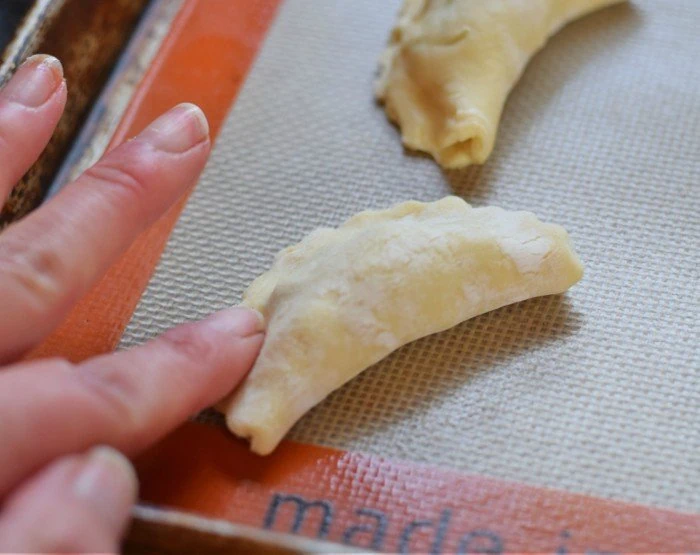 Gently press down on the edges of your empanadas to start a seal