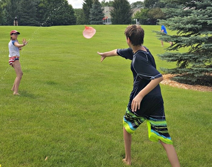 Throwing a water wubble in a water balloon fight