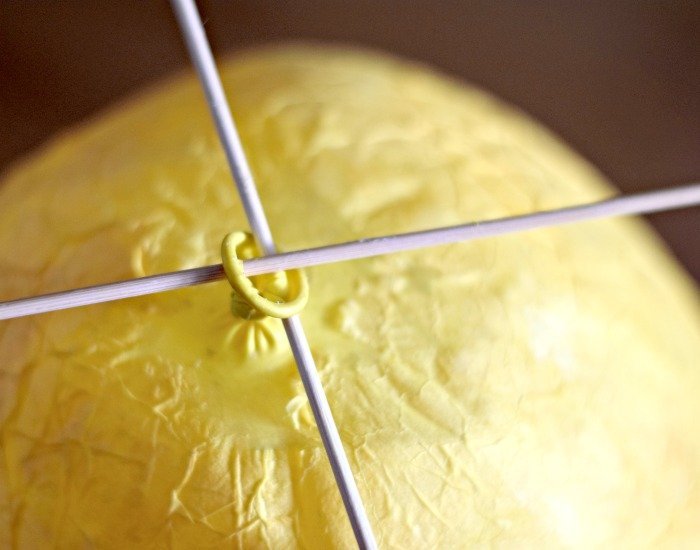 Use skewers to help hold up balloon as paper mache dries