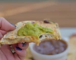 Bite of carnitas stuffed quesadilla
