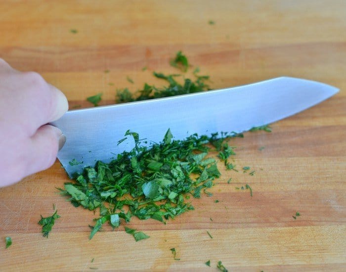 Chop herbs after running knife through log