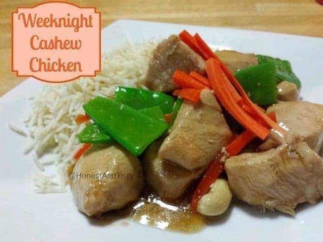 Closeup of cashew chicken over rice on a white plate with text weeknight cashew chicken.