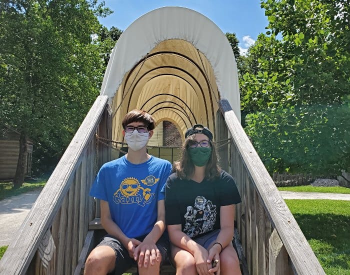 Kids sitting in a covered wagon