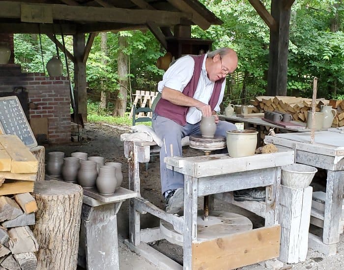Potter throwing a mug on a wheel