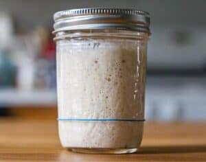 Bubbly sourdough starter in a mason jar on a counter