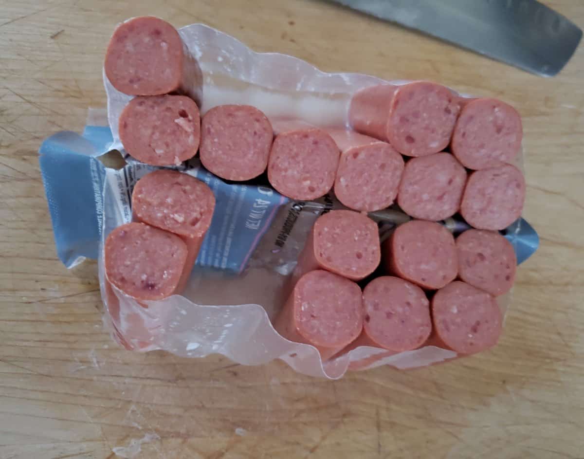 Hot dogs sliced in half standing up in the package.
