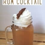 Mug of cocktail topped with whipped cream and title Hot Apple Cider Rum Cocktail.