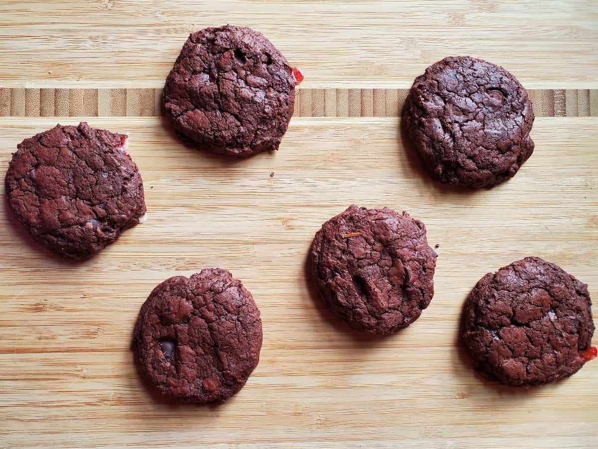 Overhead shot of chocolate candy cane cookies on a wooden board.