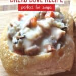 Close up of bread bowl filled with chicken rice soup and text sourdough bread bowl recipe perfect for soup.