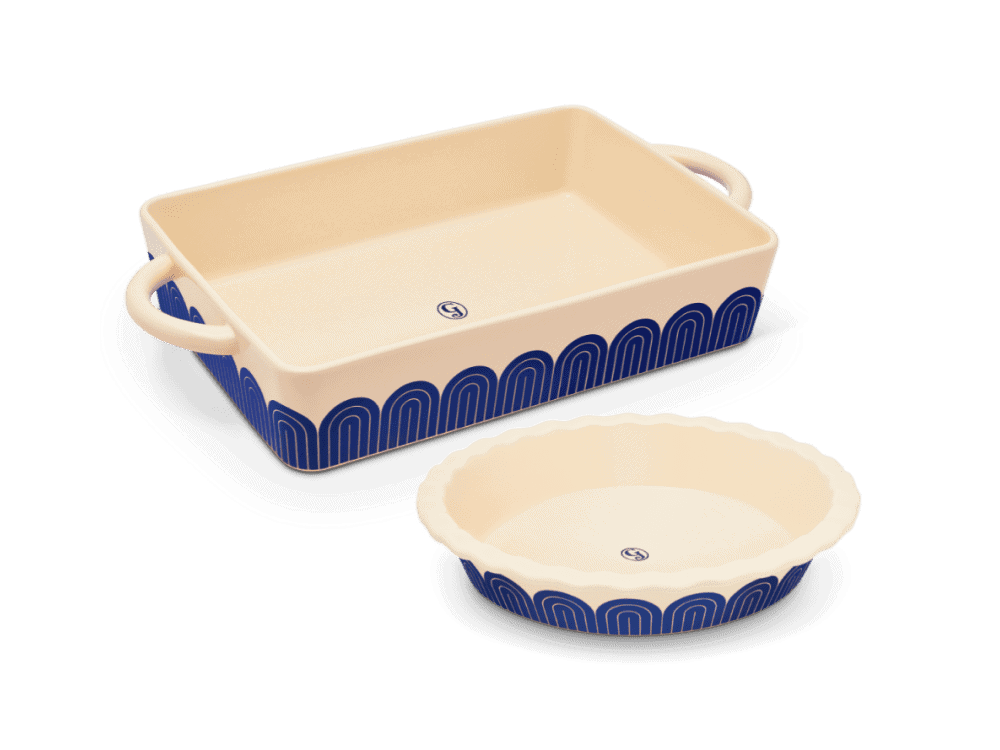 Three quarter angle of a 9x13 stoneware casserole dish and 10 inch pie dish with blue designs on the outside of each dish.