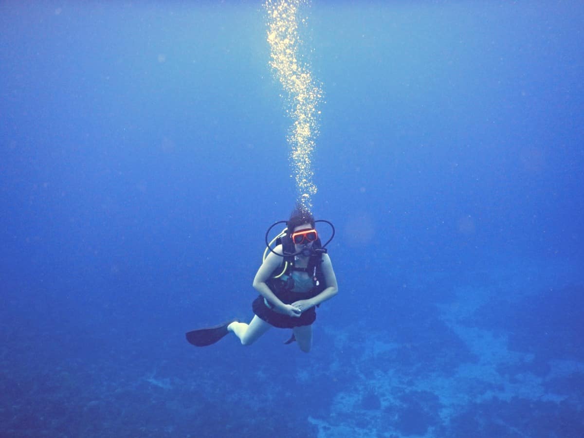 Scuba diver breathing under water facing the camera.