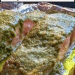 Image shows Pesto salmon on baking pan with text baked pesto salmon, easy 20 minute meal.