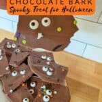 Image shows a Hand holding candy with text halloween chocolate bark spooky treat for Halloween.