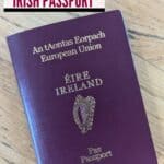 Image shows and overheard of an Irish passport on a wooden table with text how to apply for your first Irish passport.