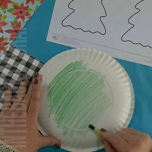 A completed Christmas tree craft made with green paper, colorful beads, pipe cleaners, and a star topper, perfect as an easy craft for kids and a festive Christmas tree craft.  Step 1 coloring the paper plate 