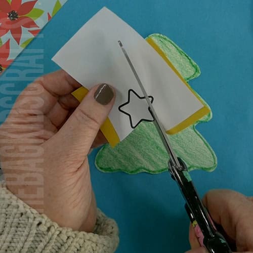 A completed Christmas tree craft made with green paper, colorful beads, pipe cleaners, and a star topper, perfect as an easy craft for kids and a festive Christmas tree craft.  step 3 cutting out the christmas star 
