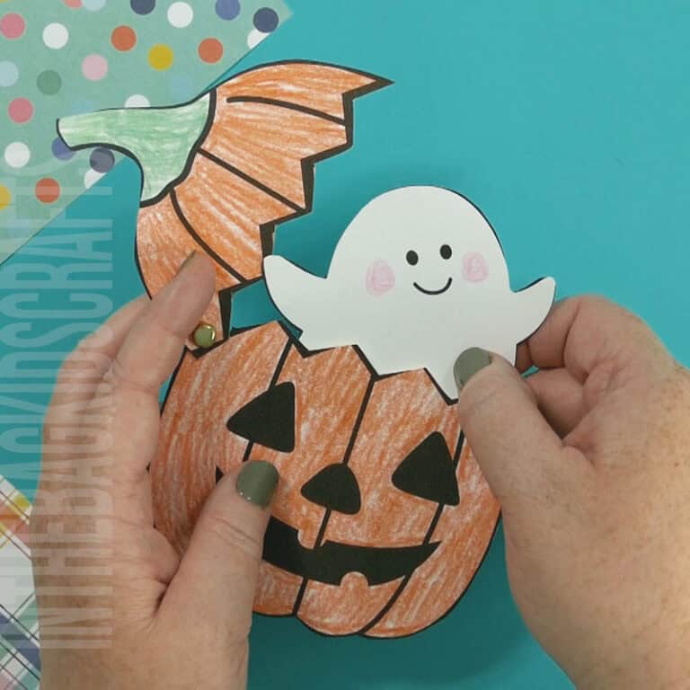 An image depicting a jack-o-lantern craft for kids, featuring a printable ghost template as part of a Halloween-themed activity.
