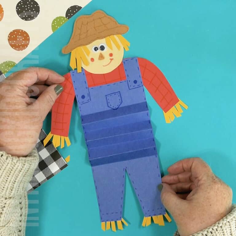 An image showing a paper scarecrow craft, perfect as an easy fall craft for kids to enjoy making.