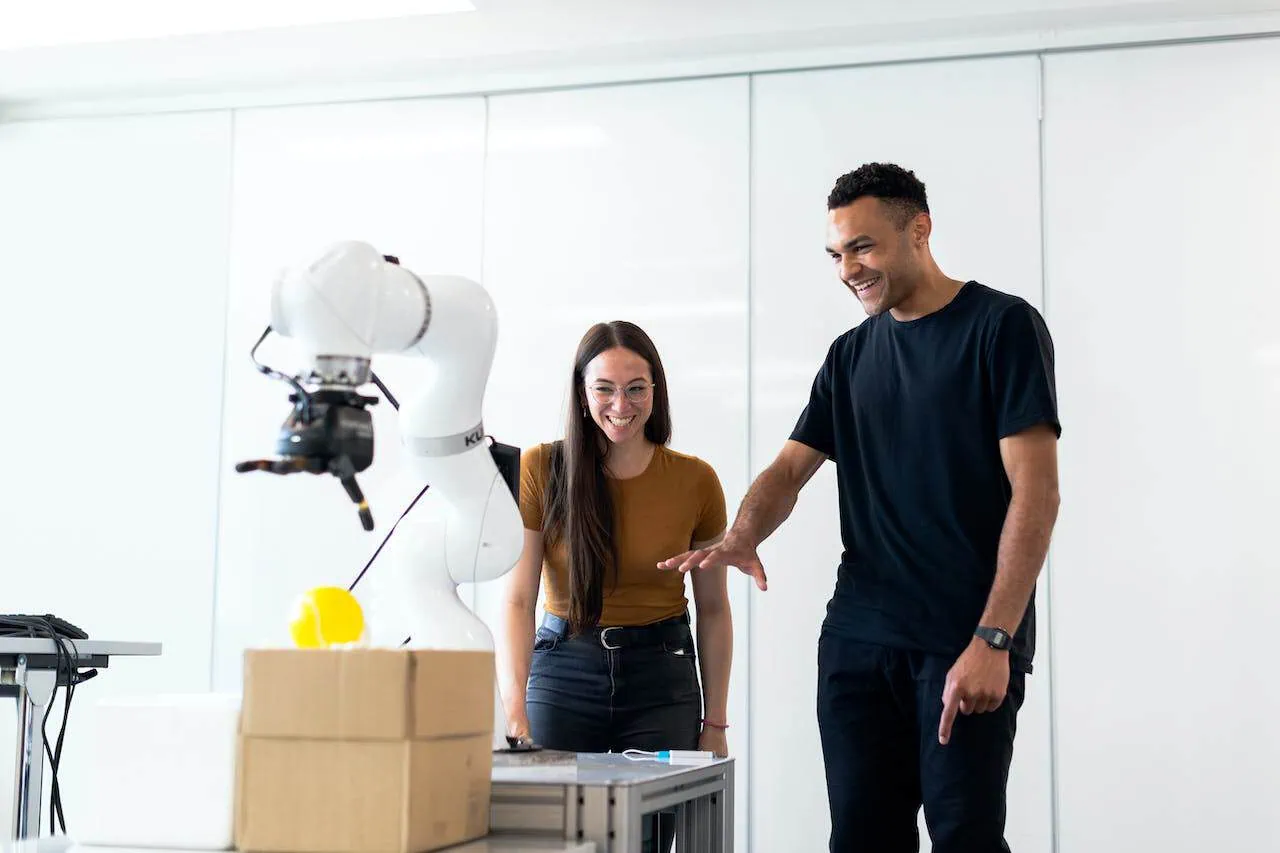 man and woman spiling at a prototype robot