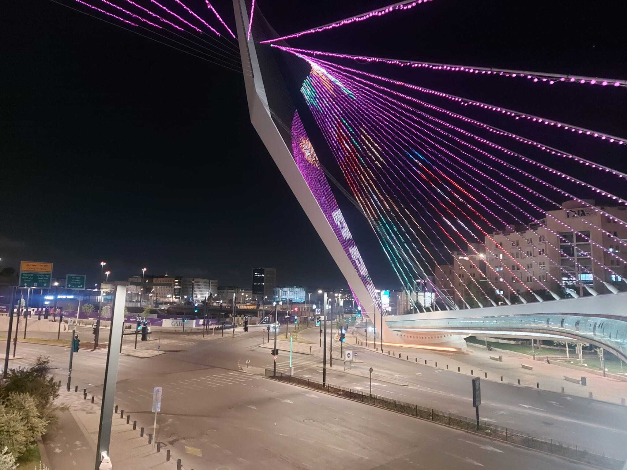 גשר המיתרים בירושלים מואר בלילה באורות צבעוניים, מבט מכיוון הכניסה לעיר